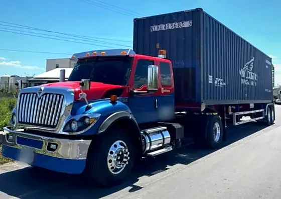 Tractomula International azul y roja con contenedor marítimo