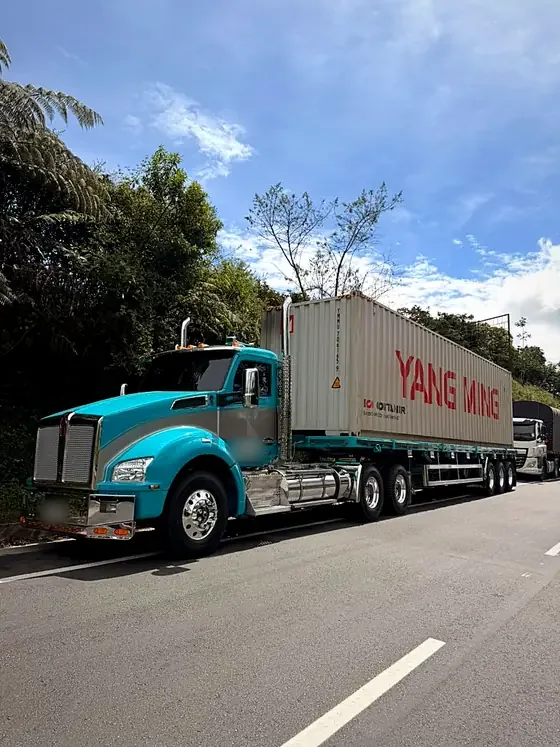 Tractomula Kenworth turquesa con contenedor Yang Ming